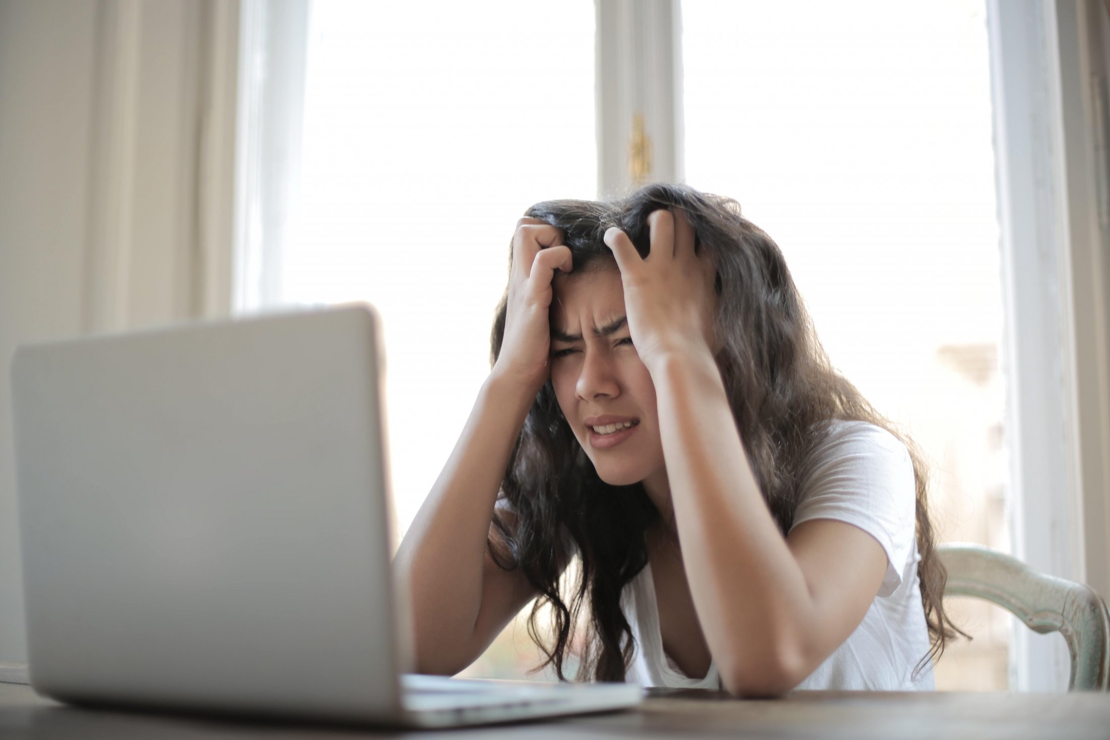 Woman at laptop looking confused and frustrated with Internet Explorer