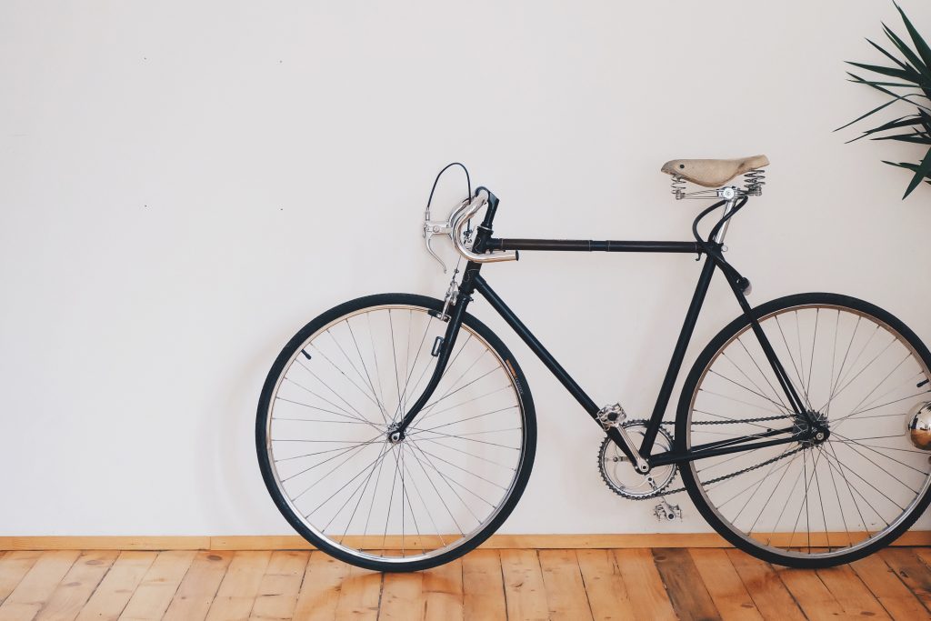 photo of a bicycle leaning against a white wall
